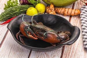 A bowl of crabs sitting on a table with other vegetables photo