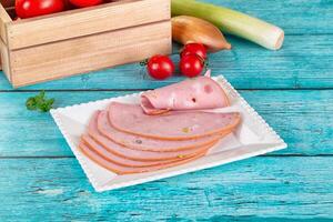 Sliced ham on a plate with tomatoes and onions photo