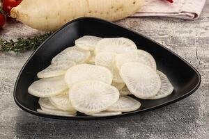 A bowl of sliced radishes on a table photo