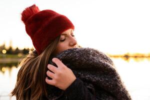 Charming woman in casual wear on shore of lake photo