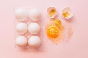 Festive Easter eggs in box and broken egg on table photo