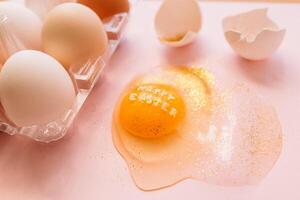 Festive Easter eggs in box and broken egg on table. photo