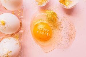Festive Easter eggs in box and broken egg on table photo