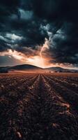 A field with plowed dirt and a stormy sky photo