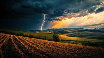 A lightning bolt strikes over a field and hills photo