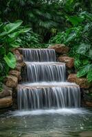 A waterfall flowing through a lush tropical garden photo