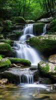 A waterfall in the woods with green moss photo