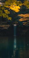 A waterfall in the middle of a forest with yellow leaves photo