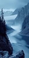 A river flows through a mountain range with trees photo