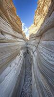 A narrow canyon with rocks and water in it photo