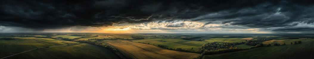 A stormy sky over a field with green grass photo