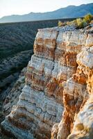 A person standing on a cliff in the desert photo
