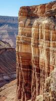 A large canyon with a blue sky and a few people photo