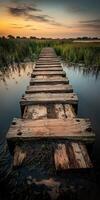 A wooden bridge over a body of water at sunset photo