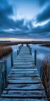 A wooden dock stretches out into the water photo