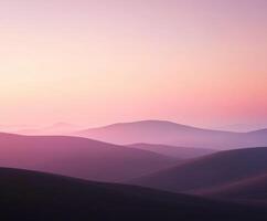 A pink and purple sunset over a mountain range photo