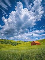 A red barn sits in a green field under a cloudy sky photo