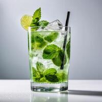 Mojito cocktail in a glass with fresh mint leaves, lime and ice. Trendy summer concept of refreshing lemonade drink with citrus. Design element photo
