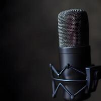 Close-up microphone on the stand wi5h copy space. On a dark background. Professional microphone on stand in recording studio, closeup. Podcast concept. photo