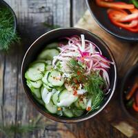 Fresh cucumber salad with red onion and dill in a bowl on a wooden background. Macro close up shoot, selective focus. Dark rustic background. photo