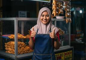 A woman in hijab standing in front of a food stand photo