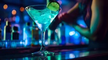 A refreshing blue cocktail garnished with a lime wedge sits on a photo