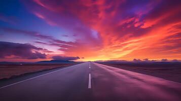 A long and winding road with a beautiful sunset in the backgroun photo