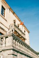 Flag of Montenegro flutters on the balcony of an ancient stone building photo