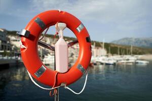 Lifebuoy on a rack with a lock at the pier against the backdrop of mountains photo
