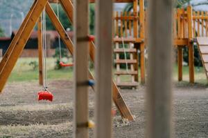 Wooden playground with swings, slides and climbing walls photo