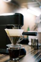 Coffee being filtered in a pour over coffee machine on the table photo