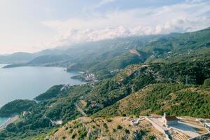 Church of St. Sava on the top of a mountain overlooking the green mountain range on the shores of the Bay of Kotor. Montenegro. Drone photo