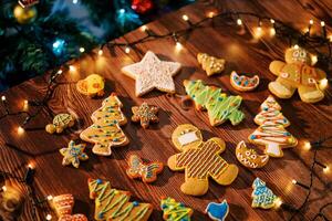 Glazed cookies lie on the table among luminous garlands. Top view photo