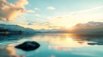 Serene lake reflecting a colorful sky at sunset with distant mountains and a foreground rock calm and inviting photo
