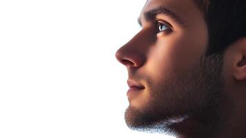 Profile of a young man against a bright white background highlighting his features and thoughtful expression photo