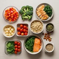 Overhead shot of nutritious meal prep featuring salmon, chicken, quinoa, and colorful vegetables. photo