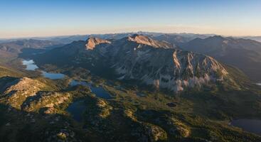 An aerial view shows a vast mountain range with pristine lakes and lush forests in North Cascades. photo