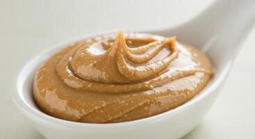 A spoonful of smooth and creamy peanut butter, ready to be enjoyed as a tasty treat. photo