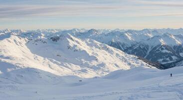 Panoramic view of snow-covered mountains under a crisp sky, ideal for winter sports and scenic explorations. photo