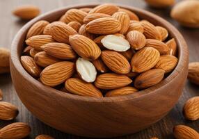 A wooden bowl overflows with healthy, raw almonds on a rustic wooden table ready for snacking. photo
