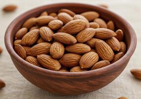 A rustic ceramic bowl is filled with delicious and nutritious almonds on a wooden table. photo