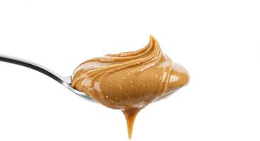 A spoonful of smooth peanut butter, showcasing its creamy texture and tempting appearance on white photo