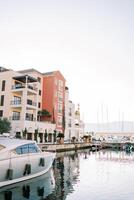 Yachts moored near the pier in front of luxury villas on the shore photo