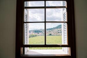 View from the window of green vineyards and a settlement at the foot of the mountains photo