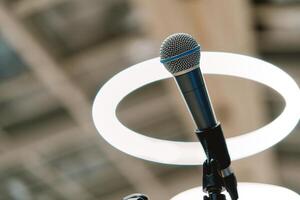 Microphone stands on a stand on the stage against the background of round lamps photo