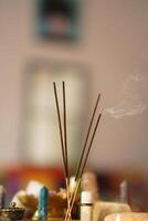 Composition with smoldering incense sticks and spa stones on blurred background photo