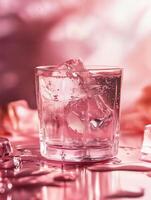 Refreshing Cocktail Glass with Ice Cubes on a Velvet Pink Background photo