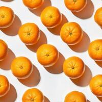 Fresh oranges arranged in a repeating pattern on white photo
