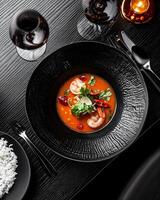 Shrimp soup served in a stylish black bowl photo