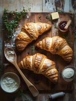 Freshly Baked Croissants with Butter and Jam on Rustic Wooden Table photo